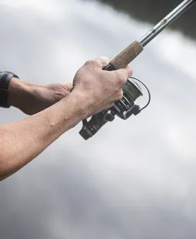 Närbild på händer med fiskespö